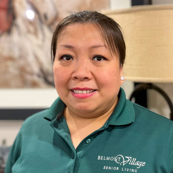 Staff member in a Belmont Village Senior Living polo shirt