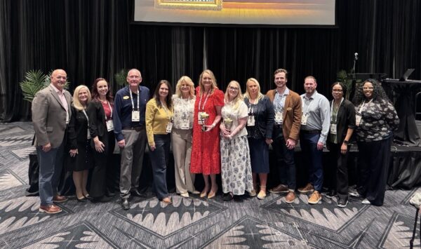Group of staff members celebrating an award in a conference room
