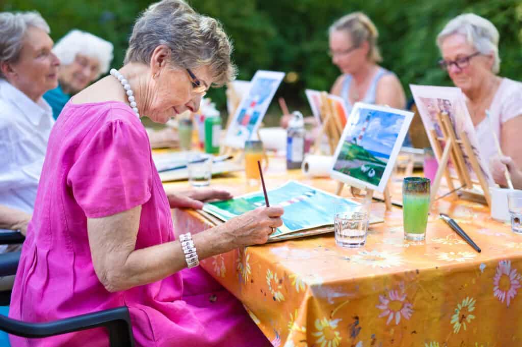 Residents participating in an outdoor painting activity