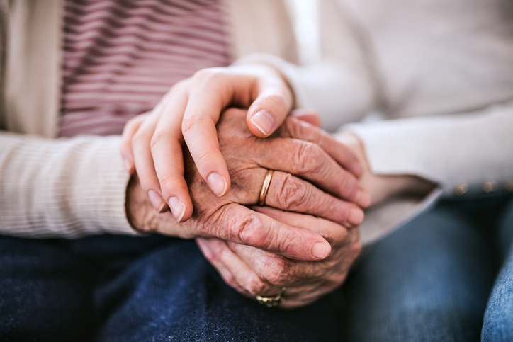Two hands holding each other, symbolizing connection and care