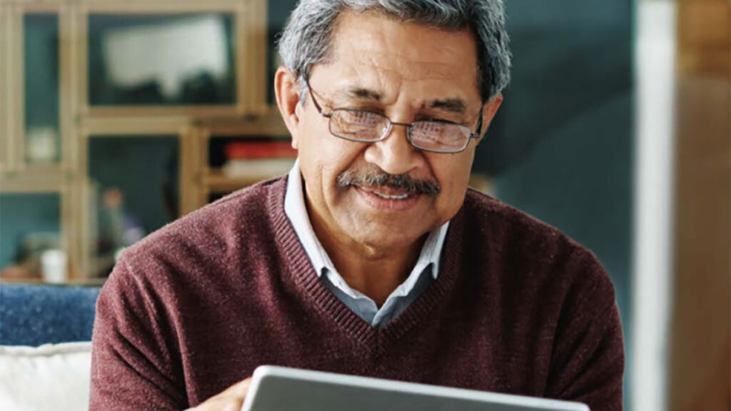 Senior man using a tablet and smiling