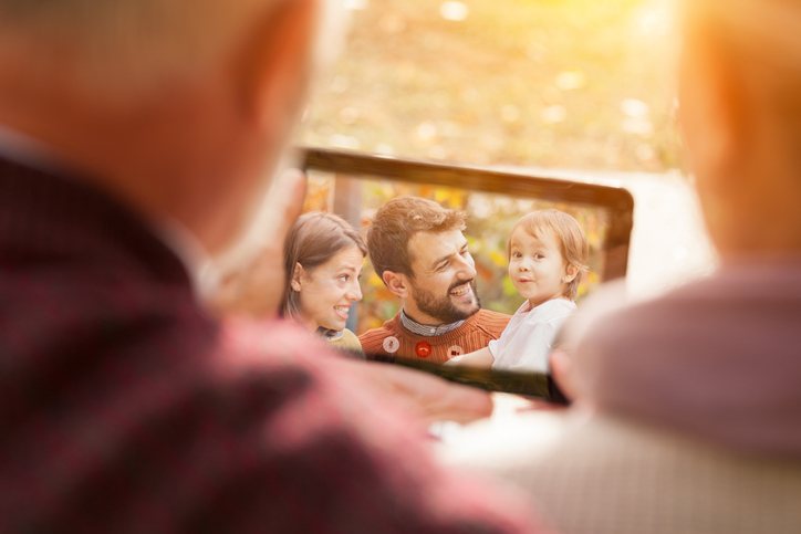 Seniors looking at a tablet showing a family photo
