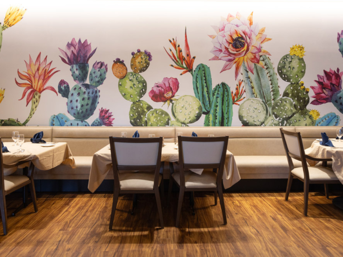 Interior dining area with vibrant cactus mural