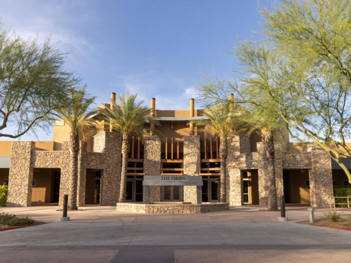 Exterior view of The Oasis facility with palm trees