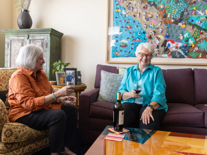 Two residents enjoying wine in a common area