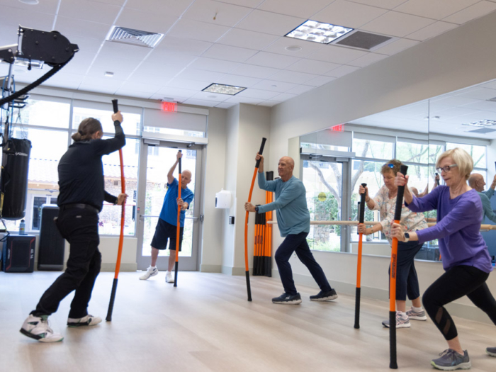 Residents participating in a group exercise class using poles