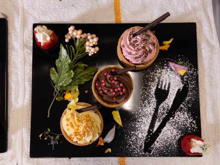 Desserts artfully arranged on a black platter