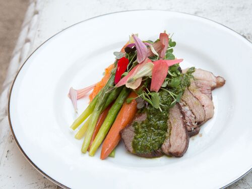 Gourmet meal plated with vegetables and herbs