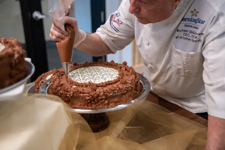 Chef decorating a chocolate cake in the kitchen