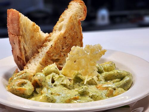 A plate of creamy pasta with garlic bread
