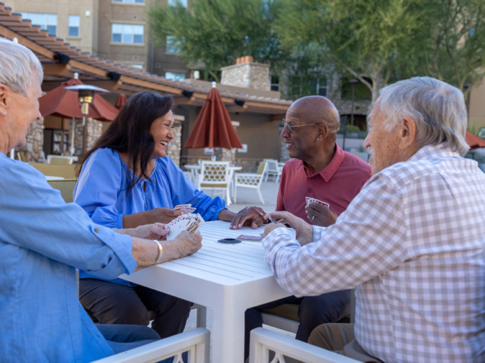 Residents playing cards outside in a garden area