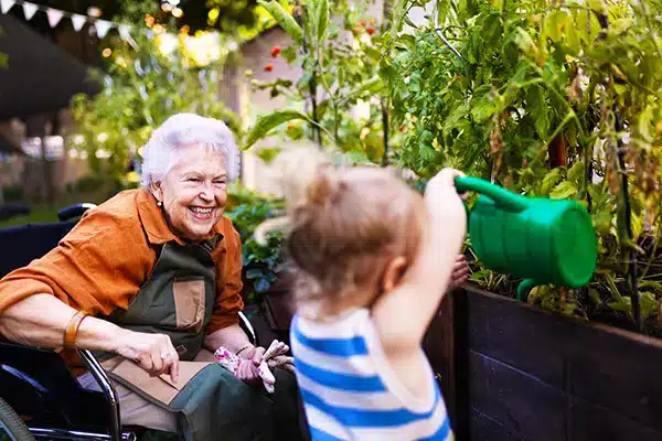 An elderly woman gardening with a young child