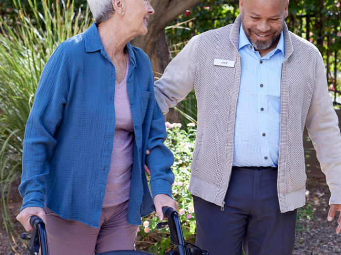 Caregiver assisting a resident in an outdoor space
