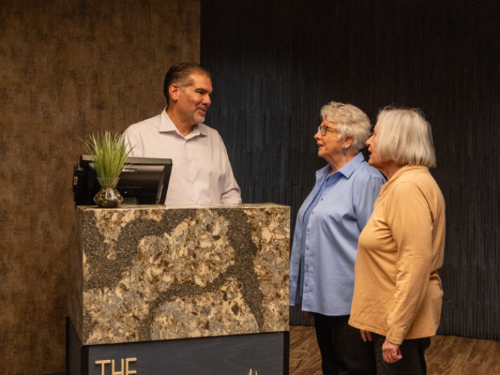 Staff assisting two residents at the reception