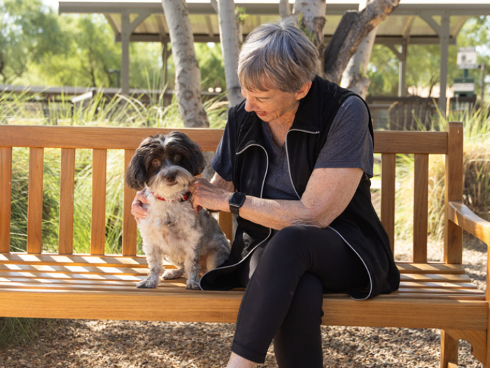 Resident enjoying time with a dog in the garden