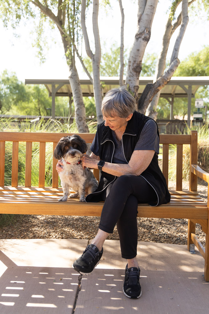 Senior resident interacting with a dog in a garden