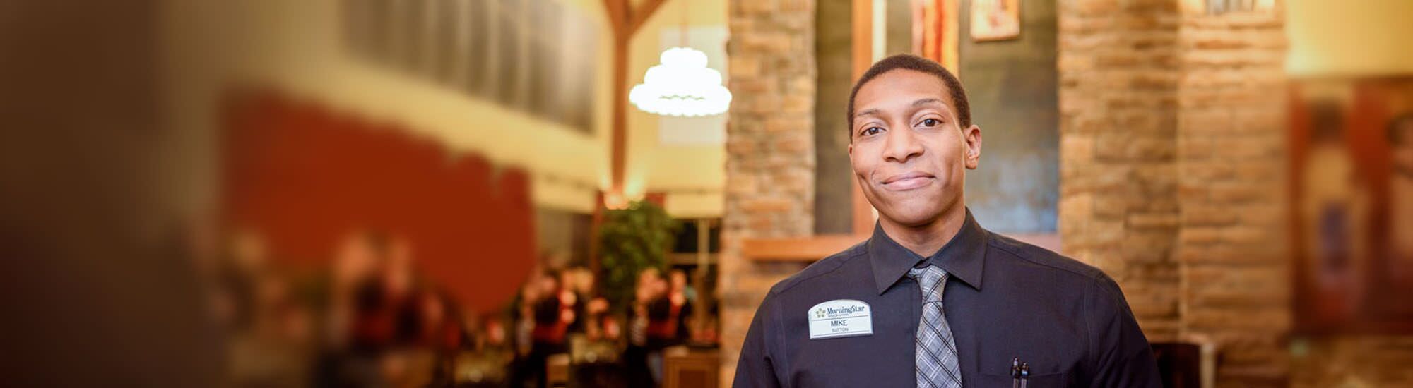 Staff member smiling in a dining area