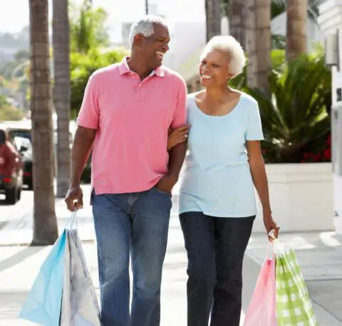 Couple shopping outdoors with colorful bags