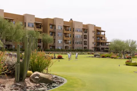 Residents enjoying the outdoor green space with building in background