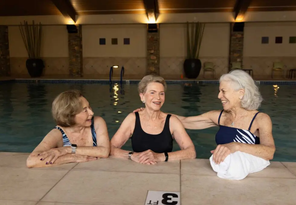 Three women relaxing by the indoor pool
