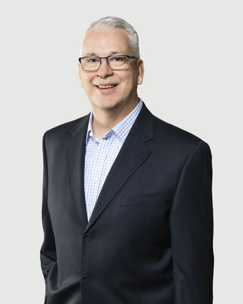 Smiling man in a suit against a plain background