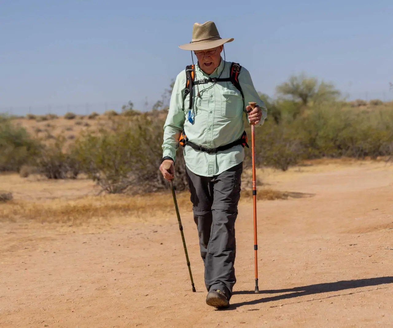 An older adult hiking on a trail