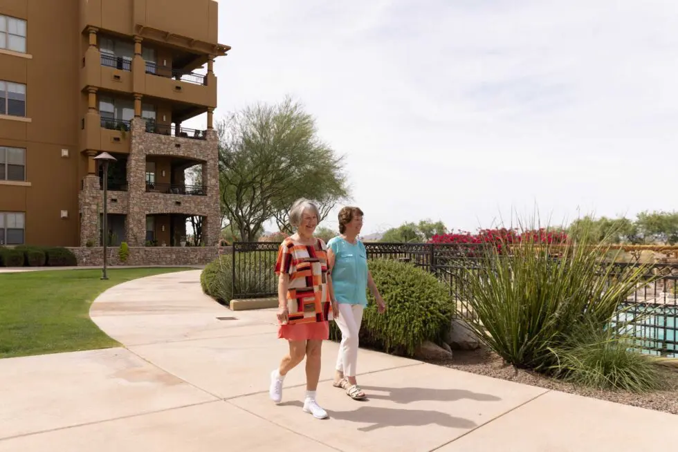 Two women walking in an outdoor area near the facility