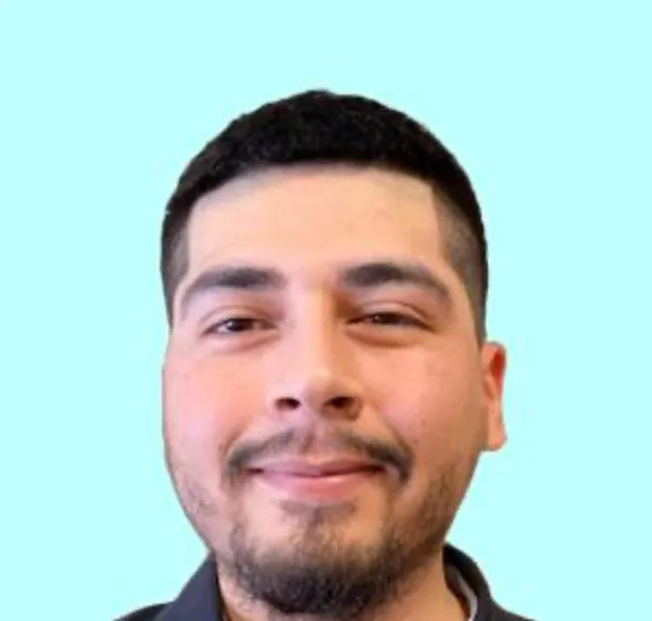 A person smiling at the camera against a plain background