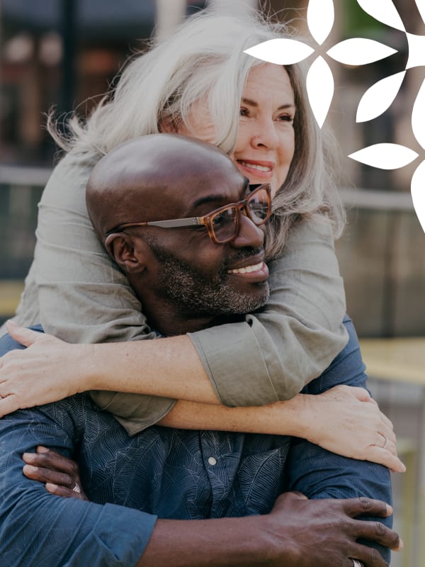 Couple enjoying outdoor hug in a relaxed setting.