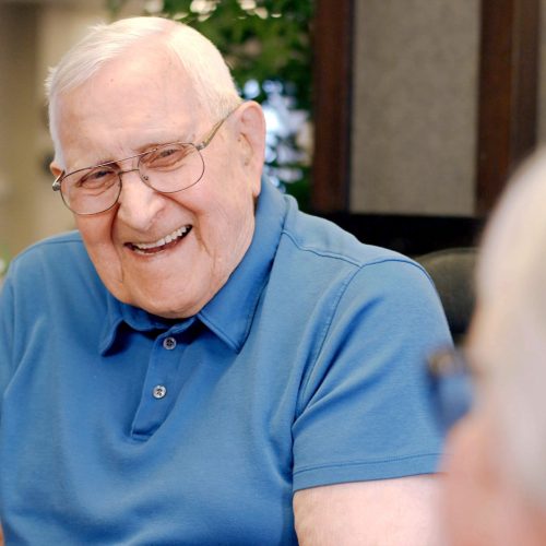 Smiling elderly man in a blue shirt