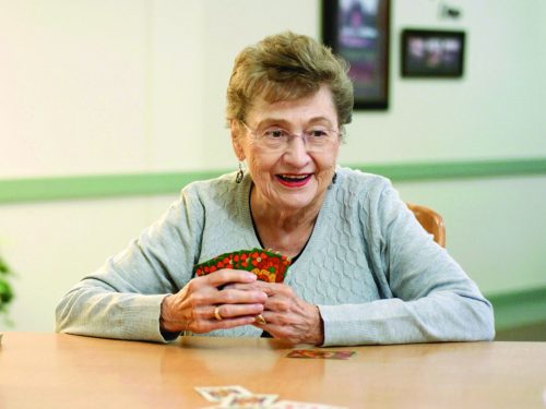 Senior woman playing cards at a table