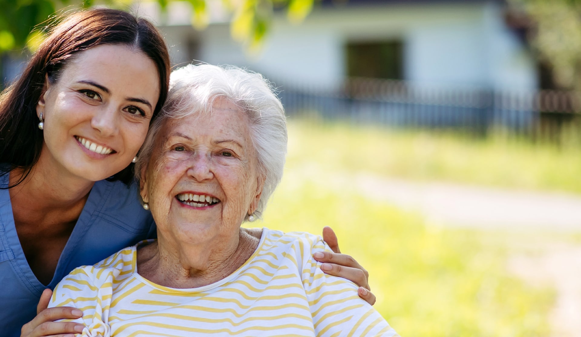 Caregiver with a smiling resident outdoors