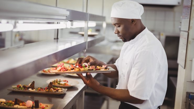 Chef preparing gourmet dishes in a kitchen.