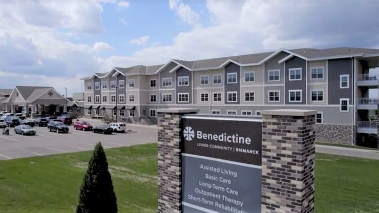 Exterior view of assisted living facility with sign.