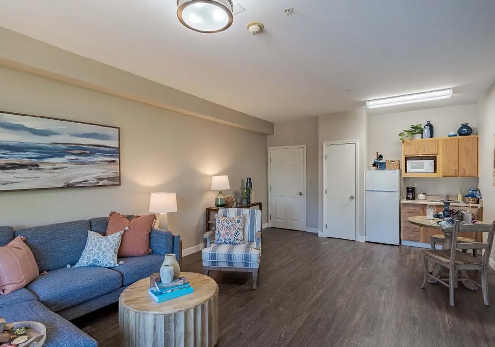 Cozy assisted living apartment with kitchen and living area.