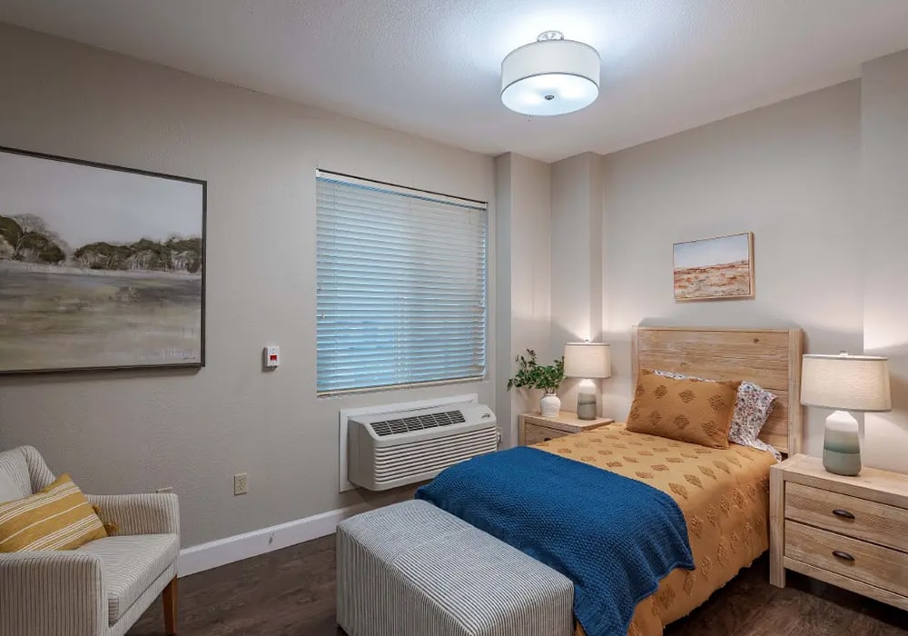 Cozy resident room with bed and furniture.