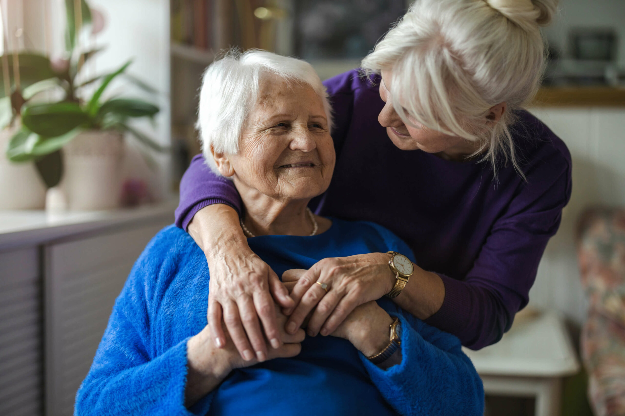 A caregiver and senior resident sharing a joyful moment.