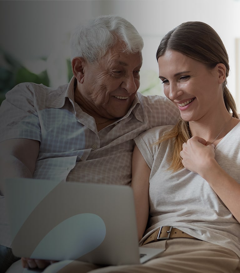 A resident enjoying time with a caregiver on a laptop.