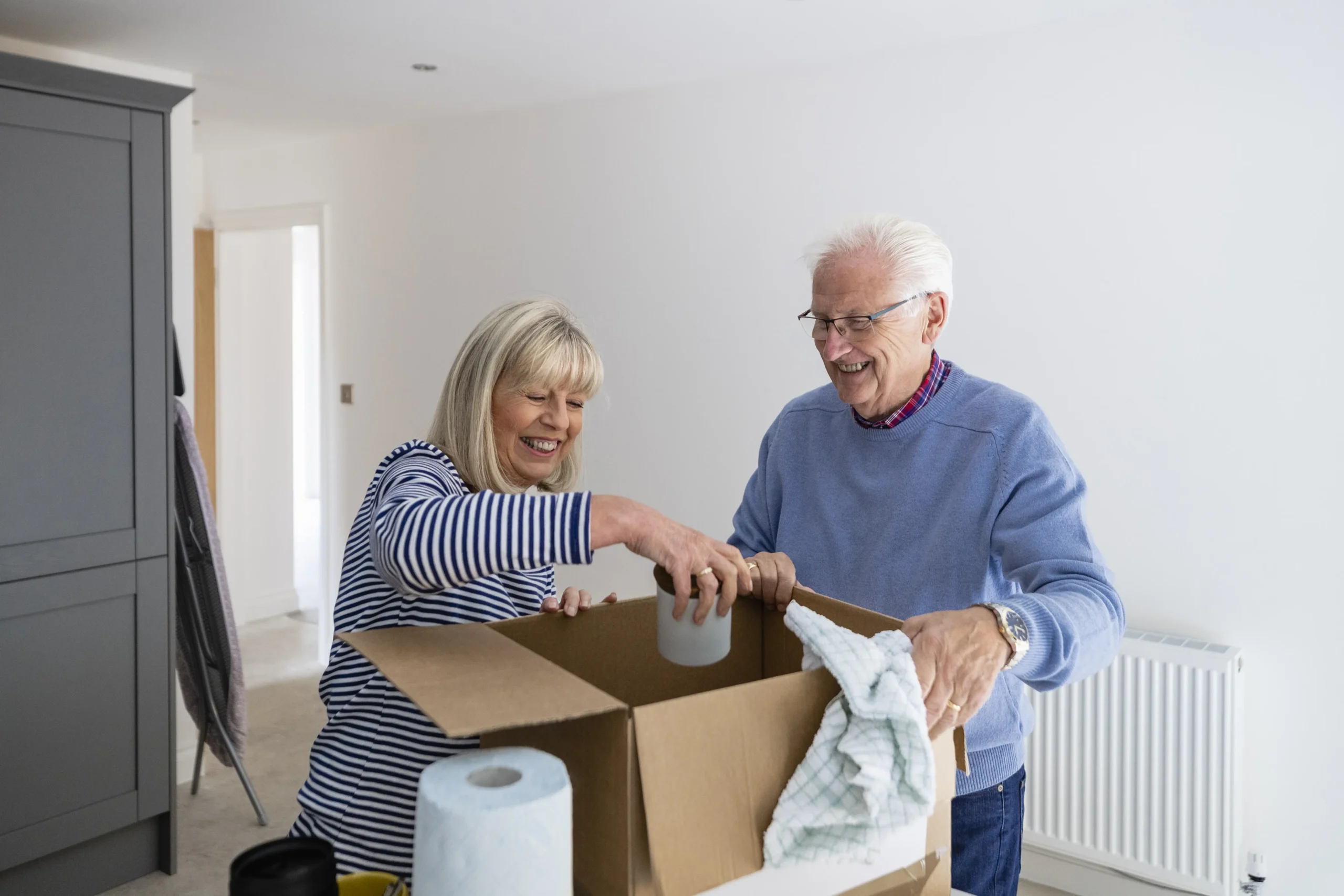 Senior couple unpacking a box together.