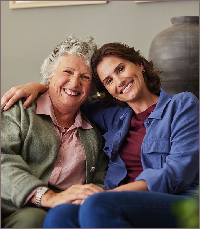 Senior resident and staff member smiling together.