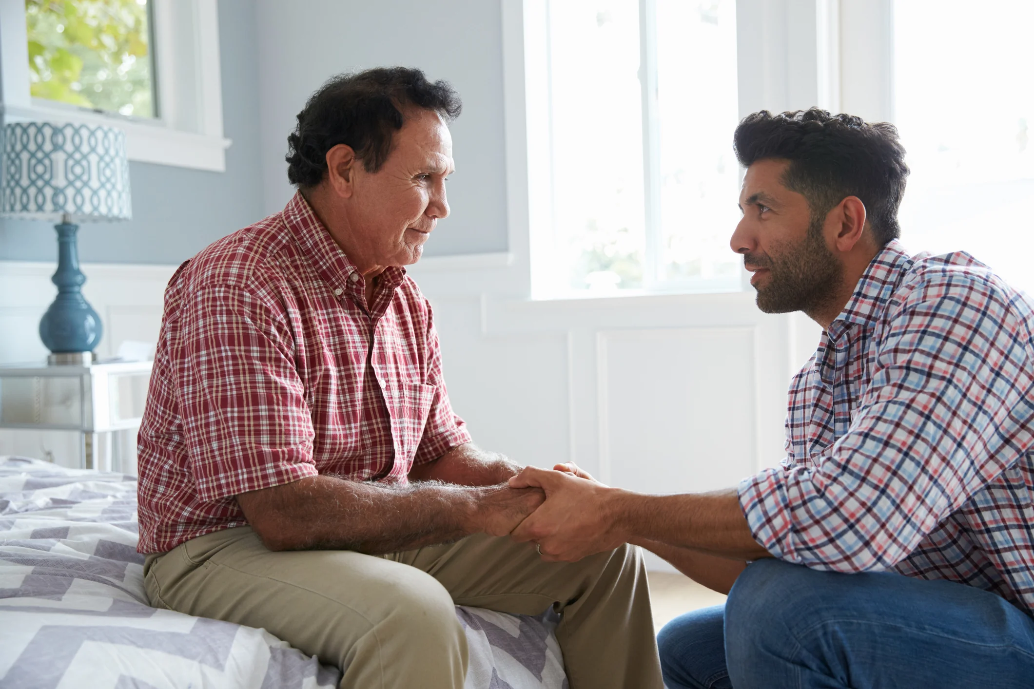 Senior man and caregiver engaged in conversation.
