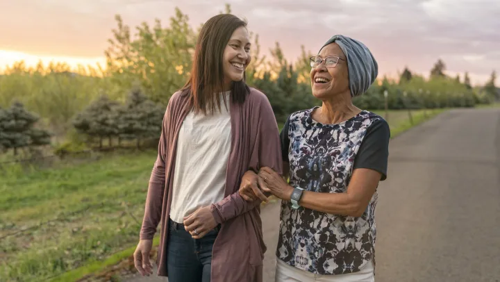 Two women enjoying a walk outdoors at sunset.