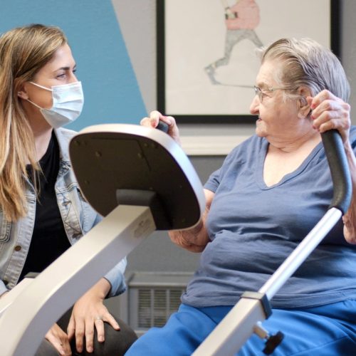 Resident engaging in exercise with staff member.