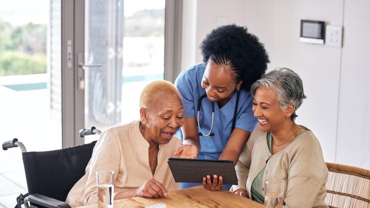 Residents engaging with staff and a tablet.