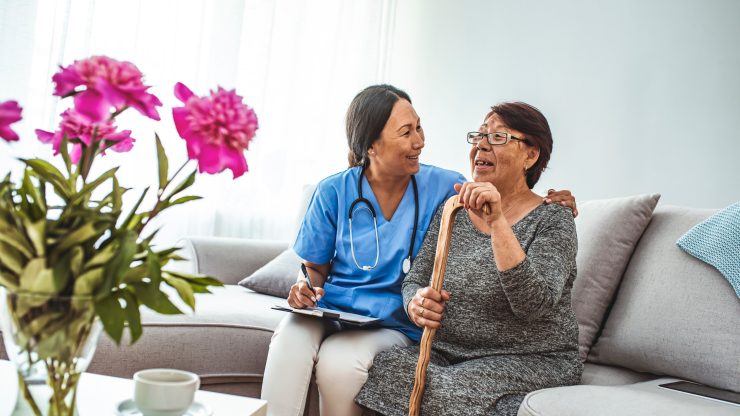 A caregiver and resident sharing a joyful moment in a living space.