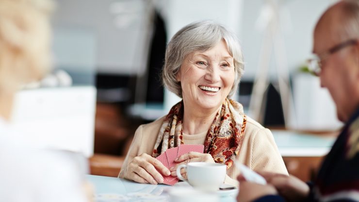 Senior woman enjoying a card game with friends