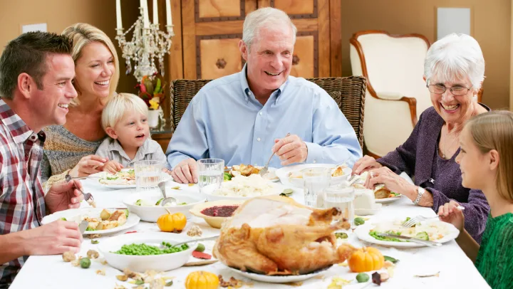 Family gathering around a dining table with food.