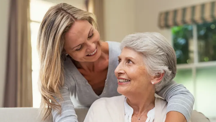 Smiling woman with older woman in a cozy setting