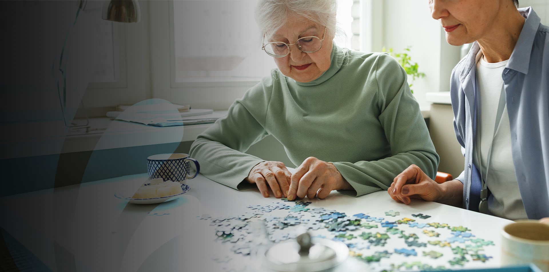 Senior woman and caregiver working on a puzzle together