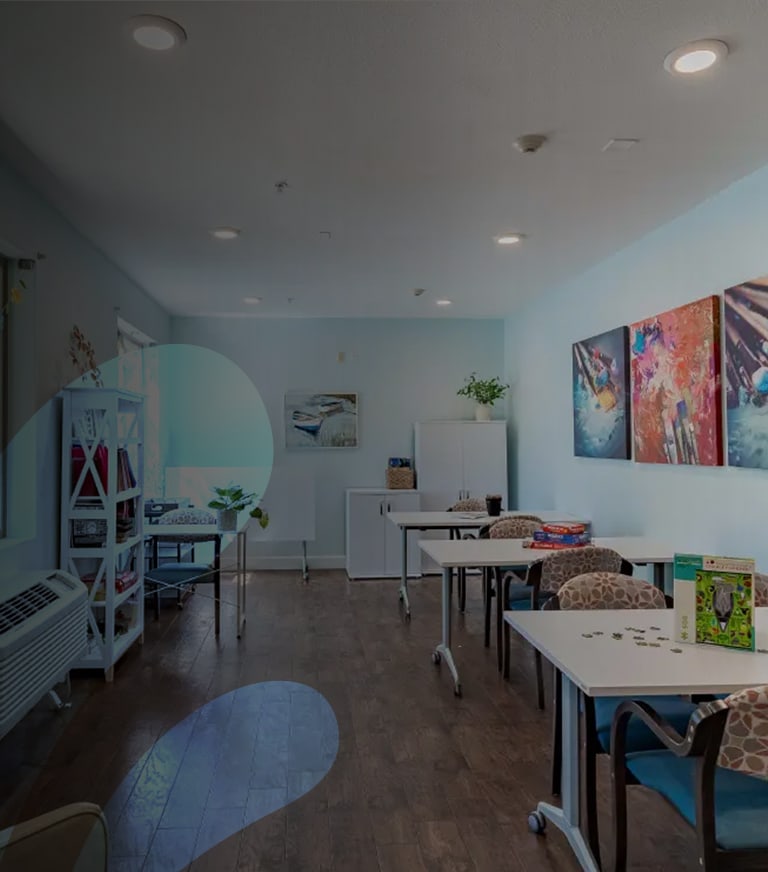 Common area with tables and artwork on the walls.